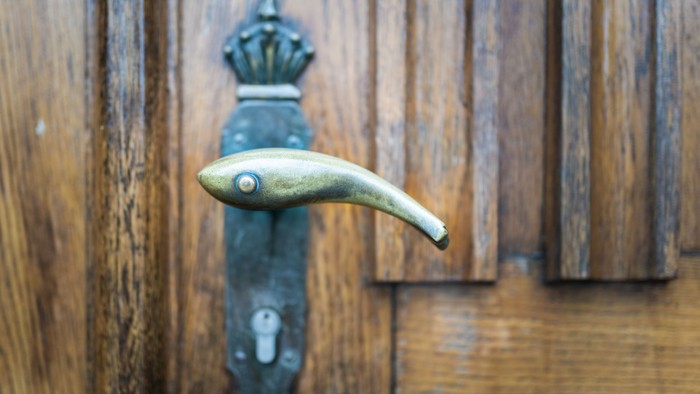 Ein antiker Türgriff an einem hölzernen Türblatt