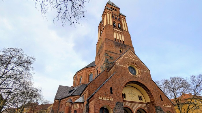 Große Ziegelkirche mit hohem Turm und Rundbogenfenster