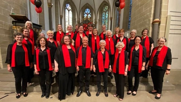 Ein großer Chor in Kirchenraum posiert für Gruppenfoto