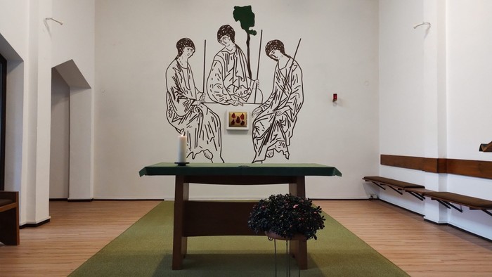 Kunstinstallation mit Tisch und Figuren, Blumenstrauß davor