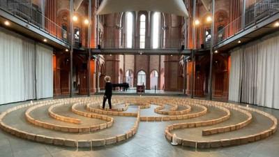 Person steht in einem Labyrinth vor einer großen Fensterfront