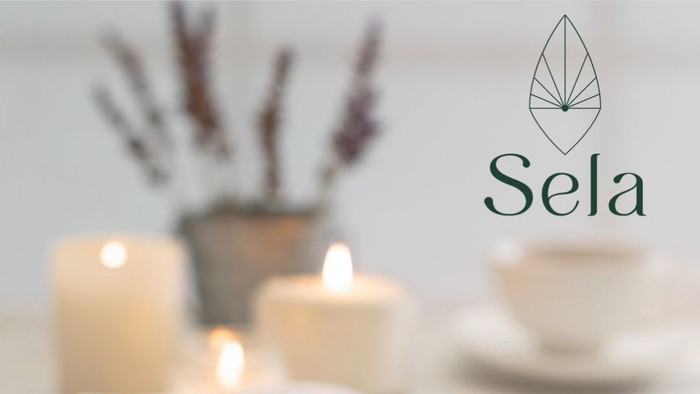 Ein offenes Buch mit Stift, Kerzen und Tee auf einem Tisch