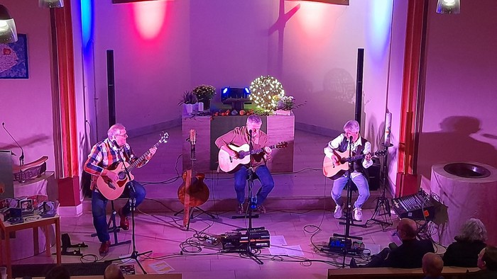 Eine Band spielt in einer Kirche Gitarren und Cello
