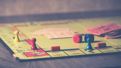 Et Monopoly-spil med brædder og terninger på et bord