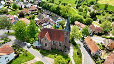 Dorf mit Kirche und umgebender Landschaft