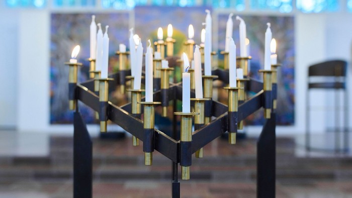 En stor sort kandleholder med guldakcentuer og mange lyse candler.