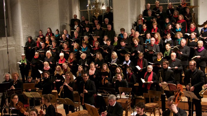 Ein großer Chor und Orchester proben in einem großen Saal