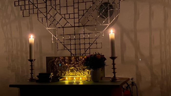 En skånselig indretning med lysende lys og blomster.