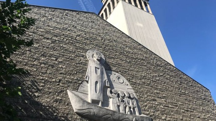 Das Bild zeigt eine Steinrelief eines Schiffes an einer Kirchenmauer.