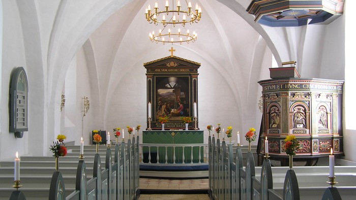 Indre del af kirke med alter og lysstake