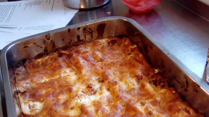 Ein Auflauf steht auf dem Herd, daneben stehen Töpfe und Schüsseln.