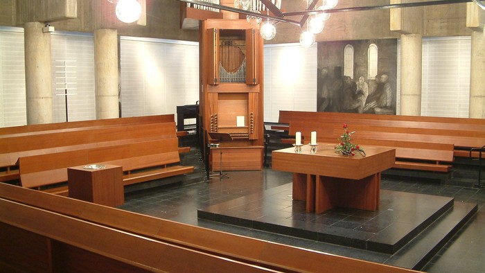 Die Kirche mit Holzgestühl und Altar im Vordergrund