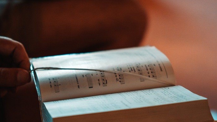 Person liest ein Buch auf einem Sofa