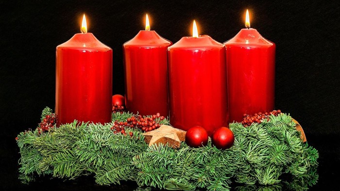 Fire røde lys på grønne fur og pynt med julekugler og stjerner