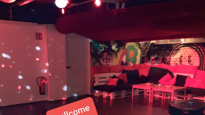 Willkommen im stylischen Partyraum mit bunten Möbeln und Diskokugel.