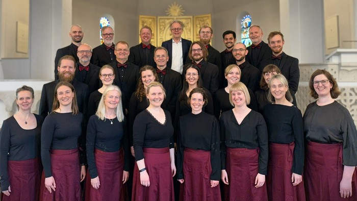 En gruppe af mænd og kvinder poserer sammen i en kirke.