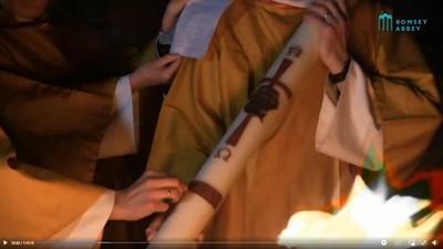 Two people preparing traditional attire, adjusting a sari with a ring and bracelet visible.