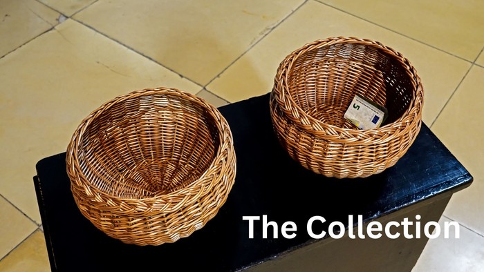 Two woven baskets on a black surface, one empty, the other containing a small item.