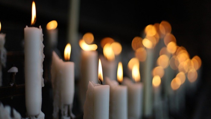 Mehrere brennende Kerzen in der Dunkelheit