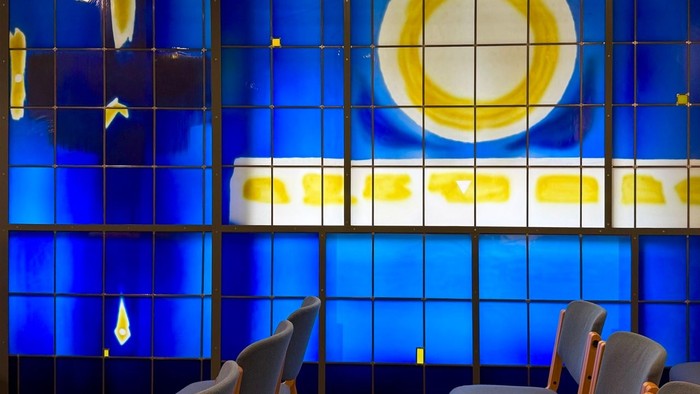 Modernes Wartezimmer mit blauen Fliesen und farbenfrohem Wandbild