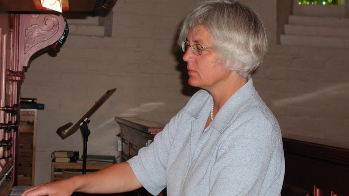 Kvinde spiller piano i stue