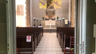 Die Kirche mit Holzstühlen und einem Altar am Ende.