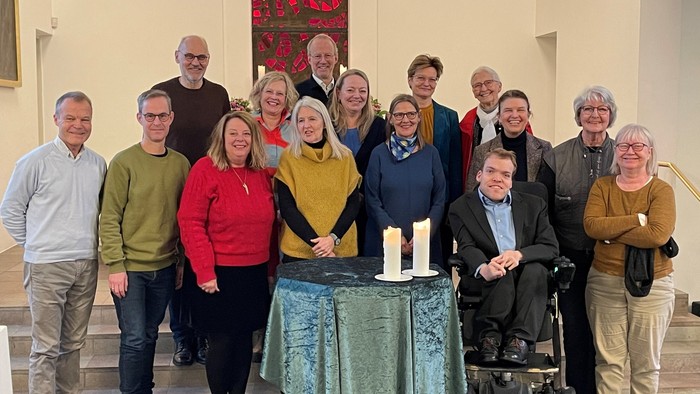 En gruppe af mennesker samlet sig i en kirke for et groupfoto.
