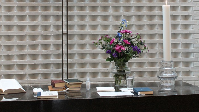 Alter med lysestage og blomsterarrangement