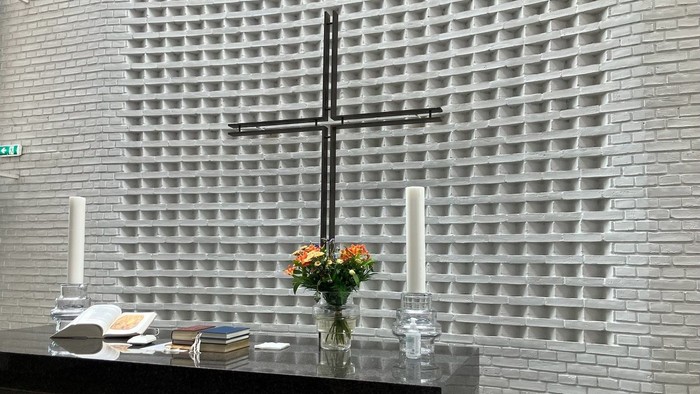 Alter med kors og blomster i kirke