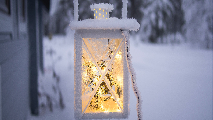 En lysende lykt dækket af sne i vinterlandskab