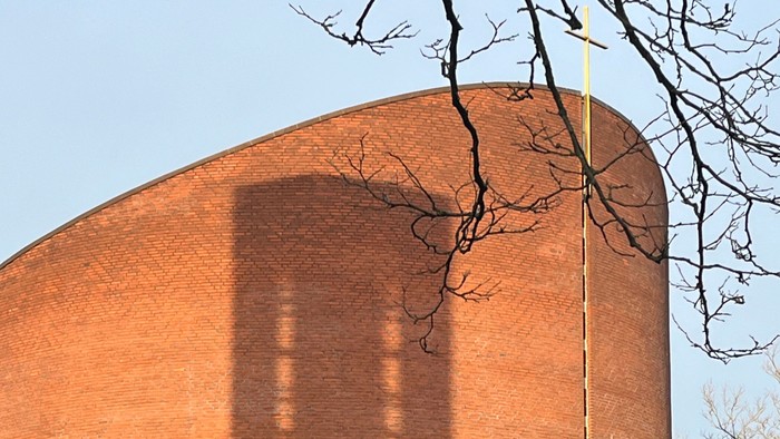 Det er et stort rødt murstensbygning med en lang skygge.