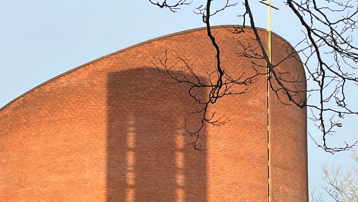 Det er et stort rødt murstensbygning med en lang skygge.