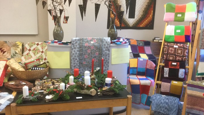 Indretning med blomster, lysstaker og farvede tekstiler