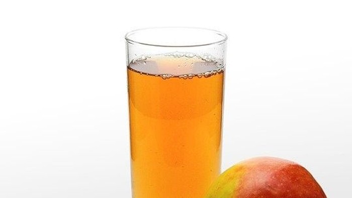 En glas med appelsin og en frisk appelsin