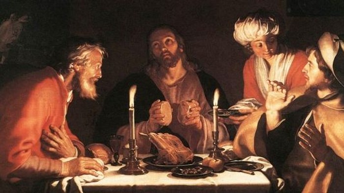 Billedet viser en gruppe mænd ved et spisebord med lyse lysstake.