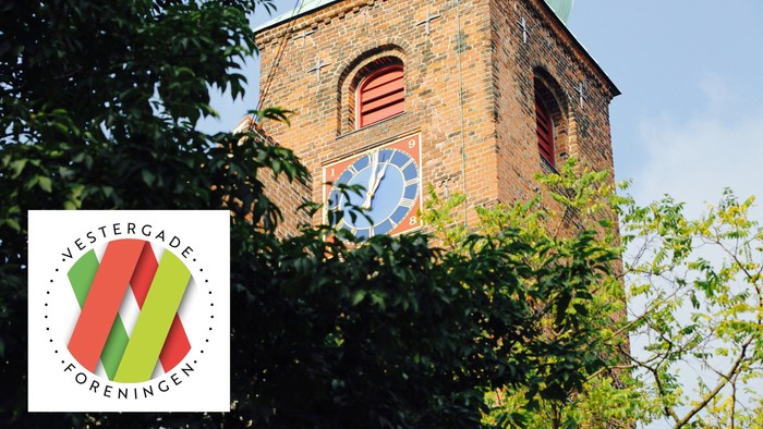 Tårn med klokke og flag ved Vestergade Forening