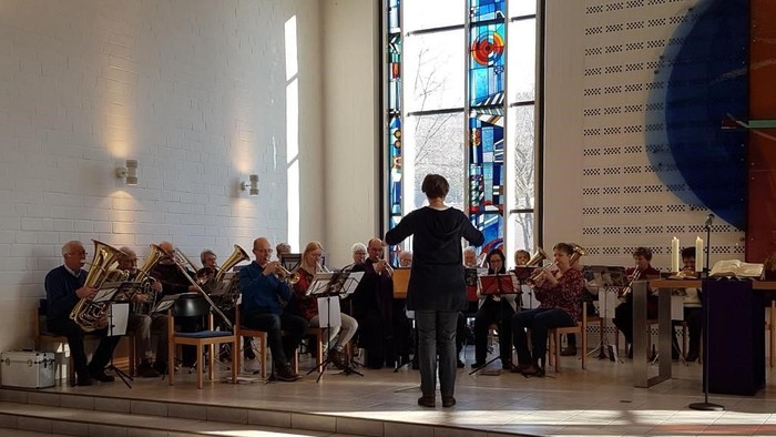 Ein Dirigent leitet ein Orchester in einer Kirche.