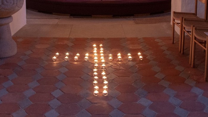 Kapel med lysende kandlelygter og alter med portræt.