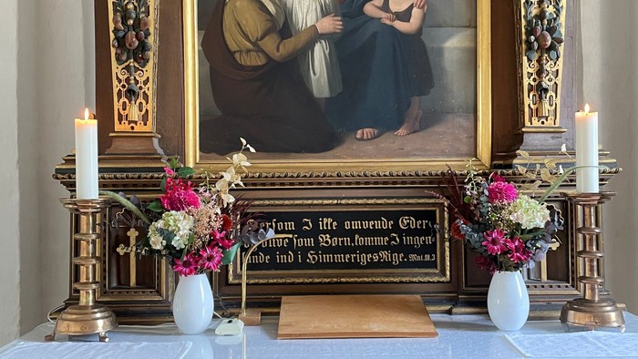 Billedet viser alter med blomster og portræt af Jesus og Maria