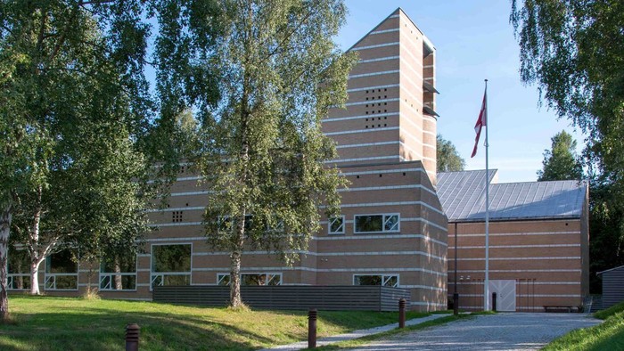 Et moderne bygning med træpanel og flagstang foran