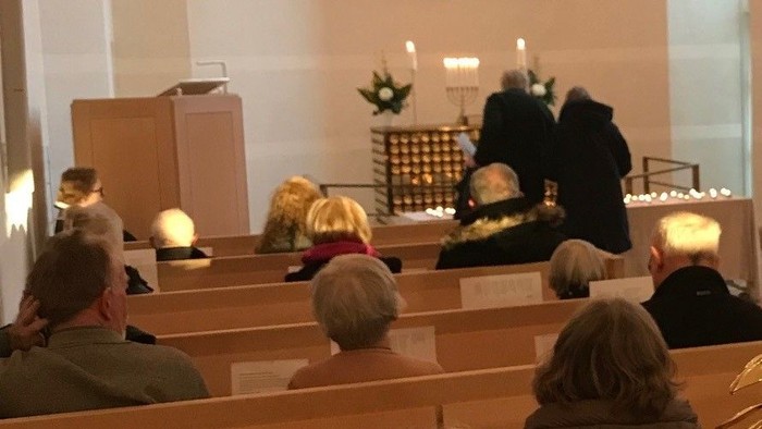 En kirke med folk, lys og lysestake