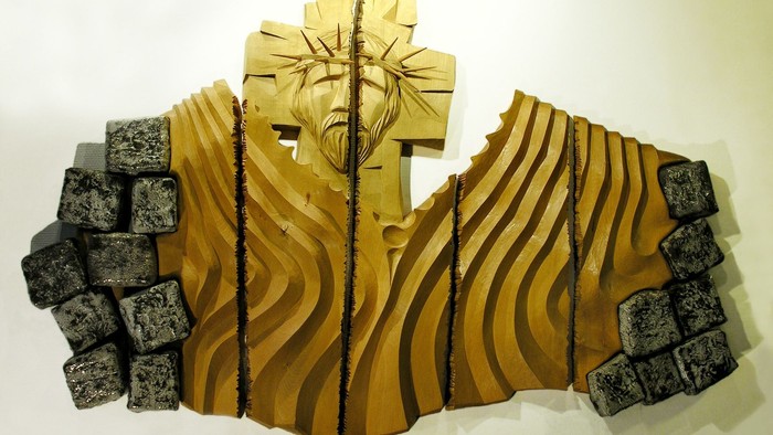 Holzskulptur eines Kreuzes mit strukturiertem Hintergrund