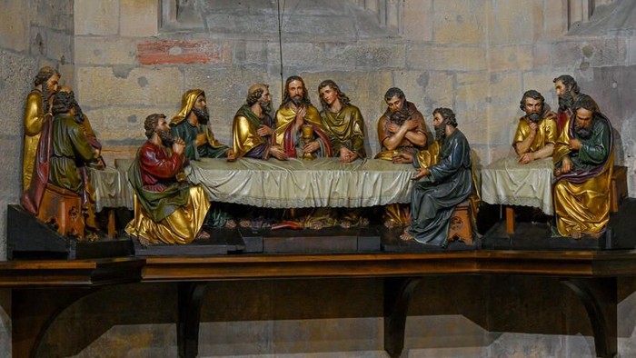 Religiöse Szene mit Figuren um einen Tisch.