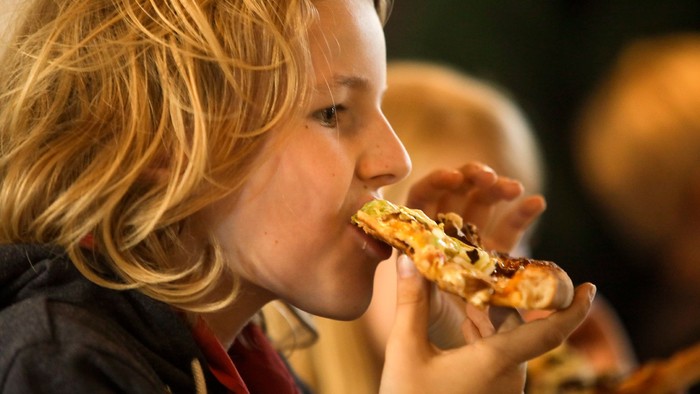 Et barn spiser en pizze.