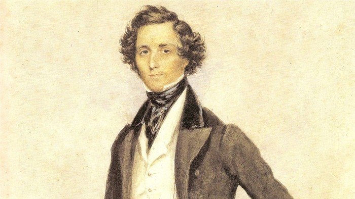 Ein Mann im Anzug mit Krawatte, Blick zur Seite.