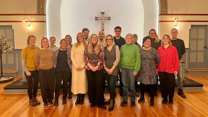En gruppe af mennesker står sammen i en kirke