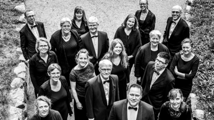 Gruppe af formelt klædte personer, der poserer udendørs.