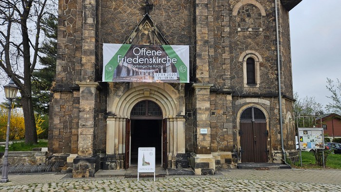 Altes Kirchgebäude mit Werbung für Offene Friedenskirche Dresden.