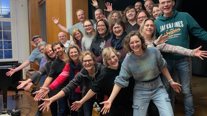 Gruppe von Personen, die gemeinsam in einem Raum posieren