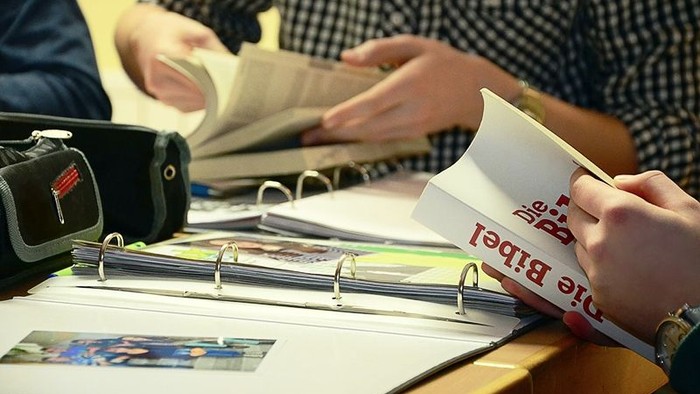 Person blättert in einem Ordner mit Fotos